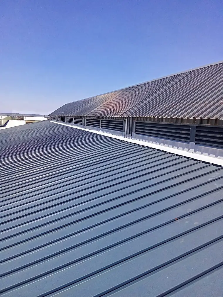 Metal roof sheeting detail against a clear sky